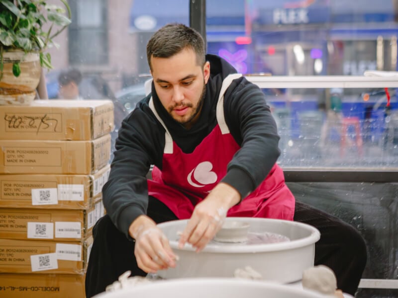 Man using a pottery wheel in a ceramics class